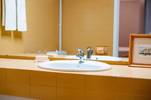 A bathroom with a white sink, a mirror, and a framed picture on the counter. - Seaside Elegance and Tranquility (Porto)