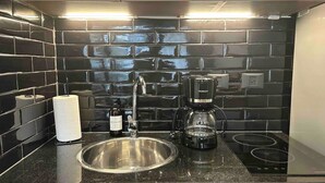 A kitchen with a stainless steel sink, a coffee maker, and a roll of paper towels. - Guatemala Studio 101 (Buenos Aires)