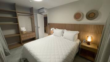 Ein Hotelzimmer mit Bett, Nachttisch, Kleiderschrank und Deckenleuchte.