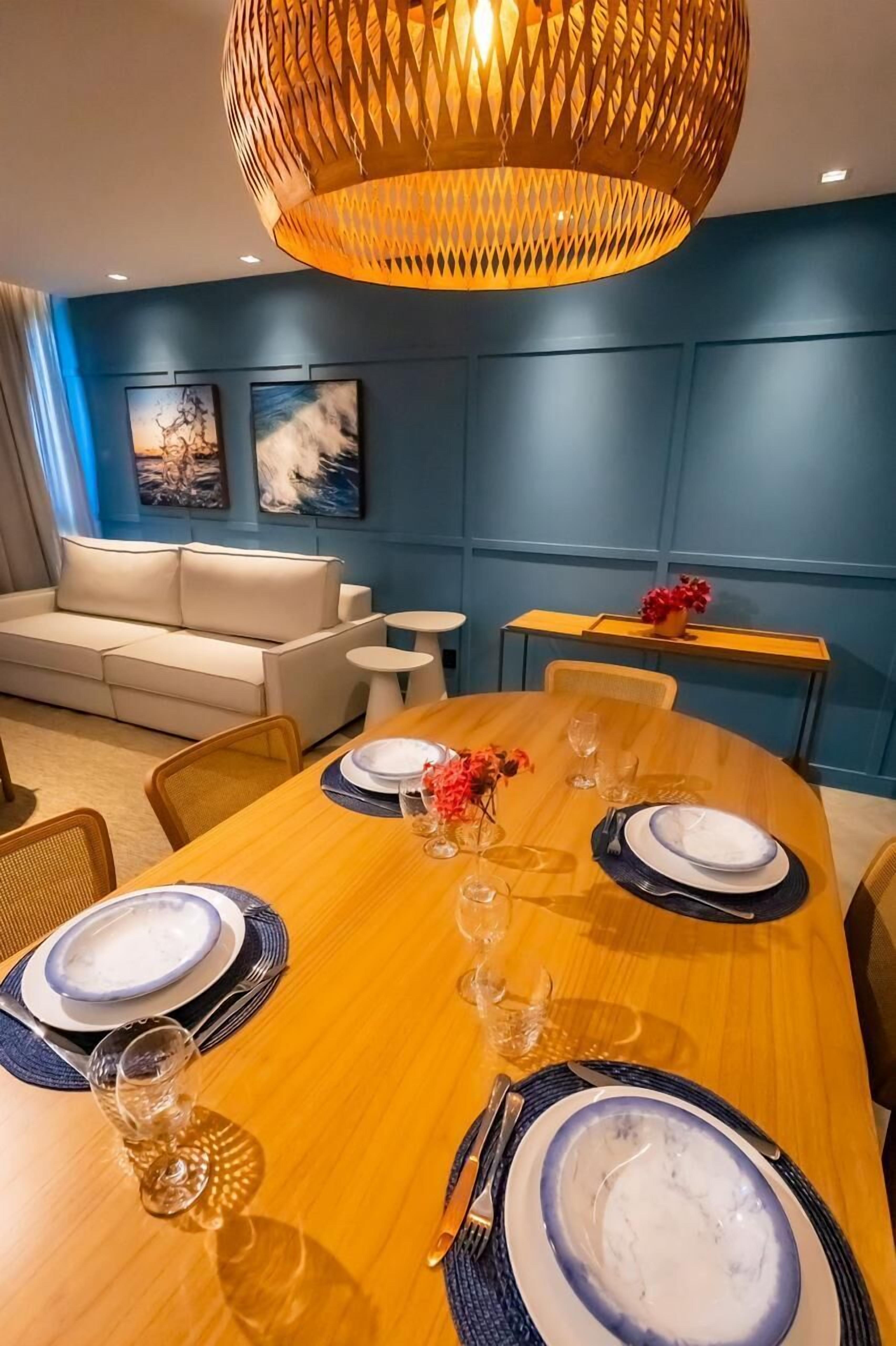 A dining area with a wooden table set for four, a sofa, and a small side table.