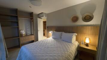 A neatly arranged bedroom with a bed, bedside table, lamp, and a wardrobe.