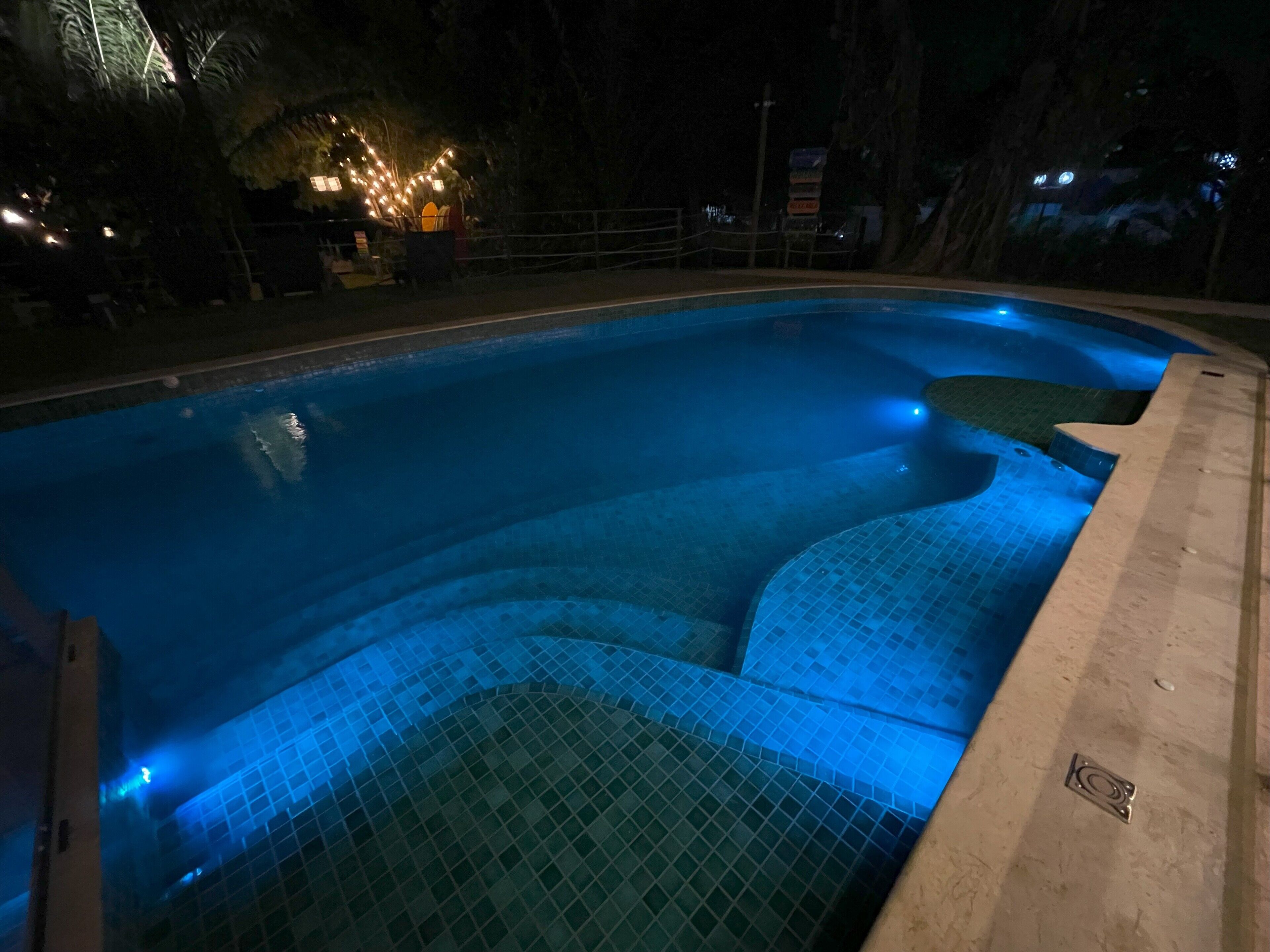 Una piscina con borde de azulejos y tapa de desagüe.