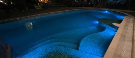 Una piscina con borde de azulejos y tapa de desagüe.