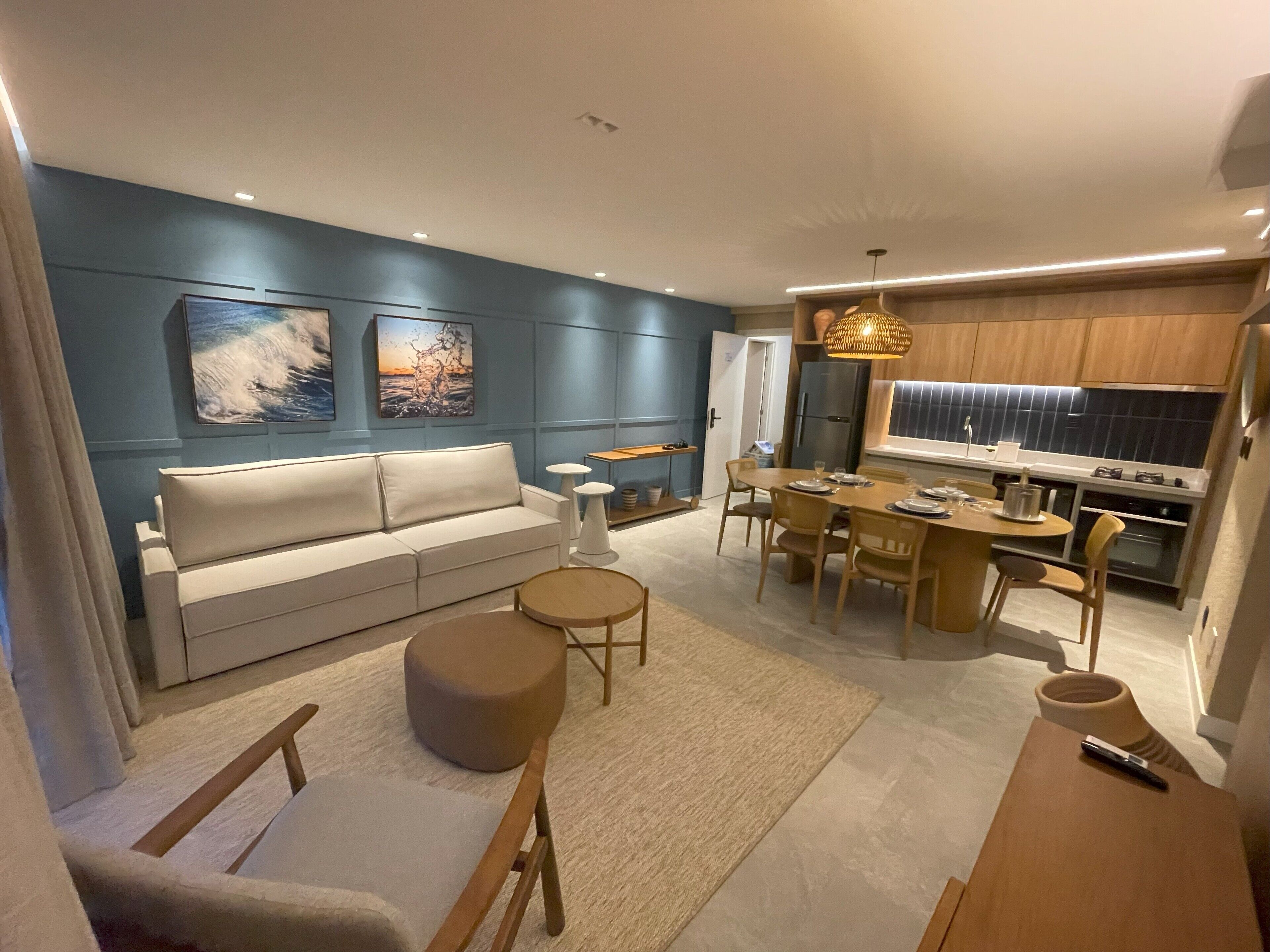 Un salon moderne comprenant un canapé, une table basse et un coin repas avec des chaises et une table.