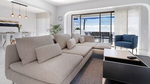 Een moderne woonkamer met een modulaire bank, een salontafel en uitzicht op het omliggende landschap.