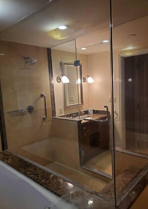 Une salle de bain moderne avec une douche à parois de verre, un meuble-lavabo et un grand miroir.