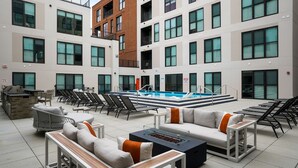 Un espace piscine sur le toit, comprenant des chaises longues, un foyer et une piscine.