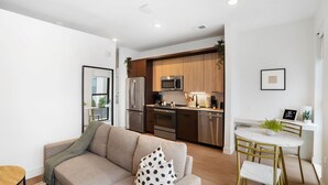 Un appartement moderne comprenant un salon, une cuisine et un coin repas.