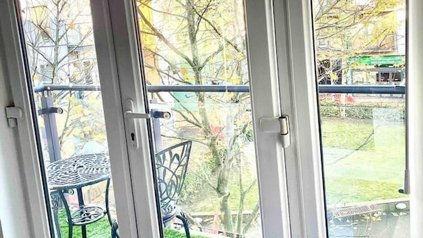 A room with a large window overlooking a grassy area and a metal table. - Peaceful Impeccable 2-bed Apartment in Hatfield (Hatfield)