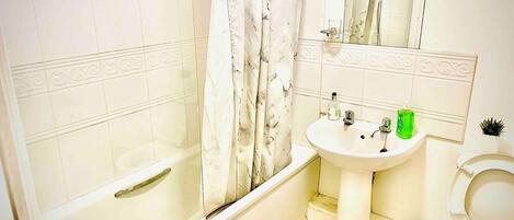Un baño con bañera, lavabo e inodoro.