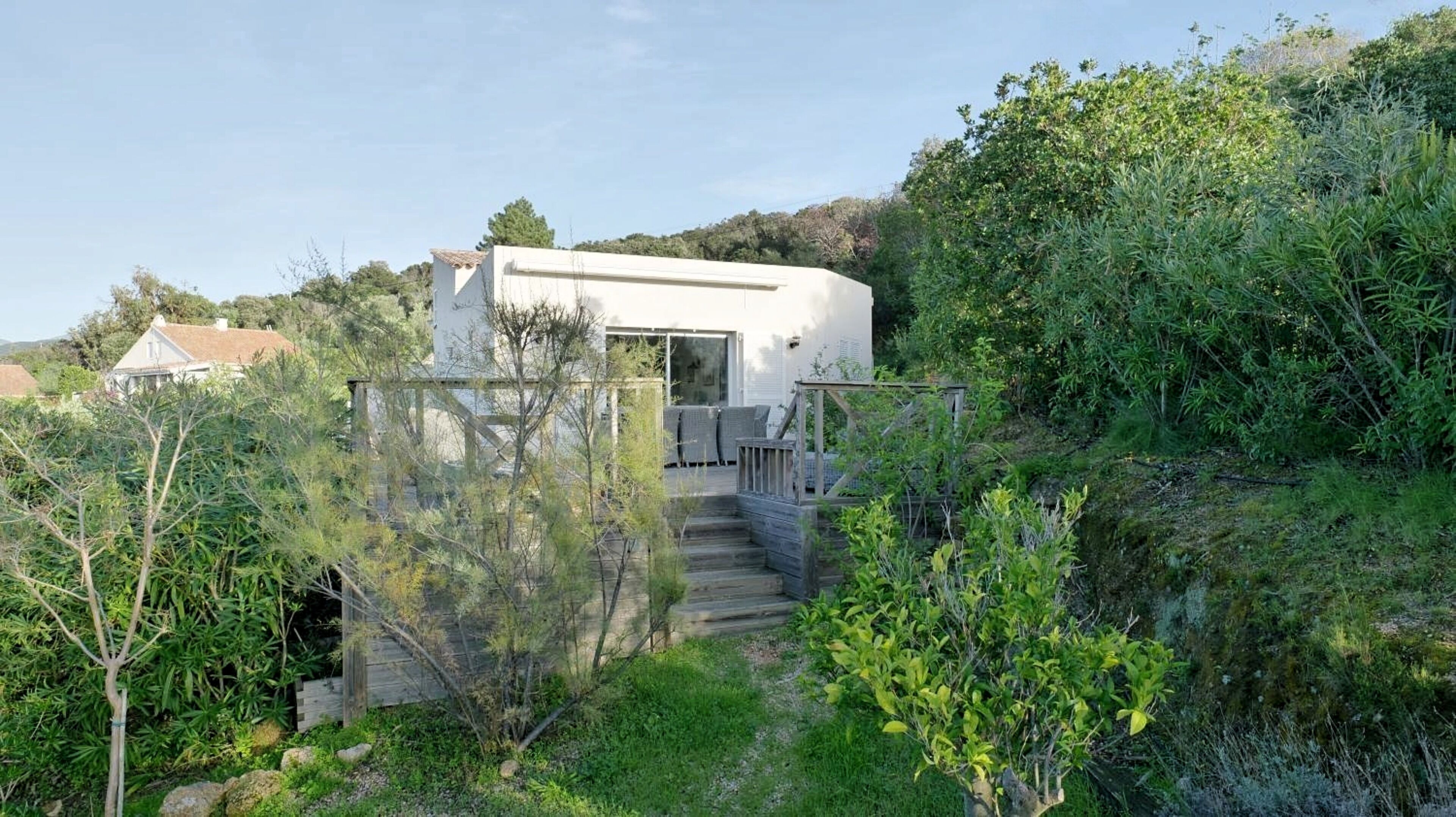 A modern house with a staircase leading to a covered outdoor area.