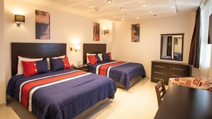 A hotel room with two beds, a dining table, a mirror, and artwork on the walls. - Hotel Grand Elizabeth Durango (Durango)