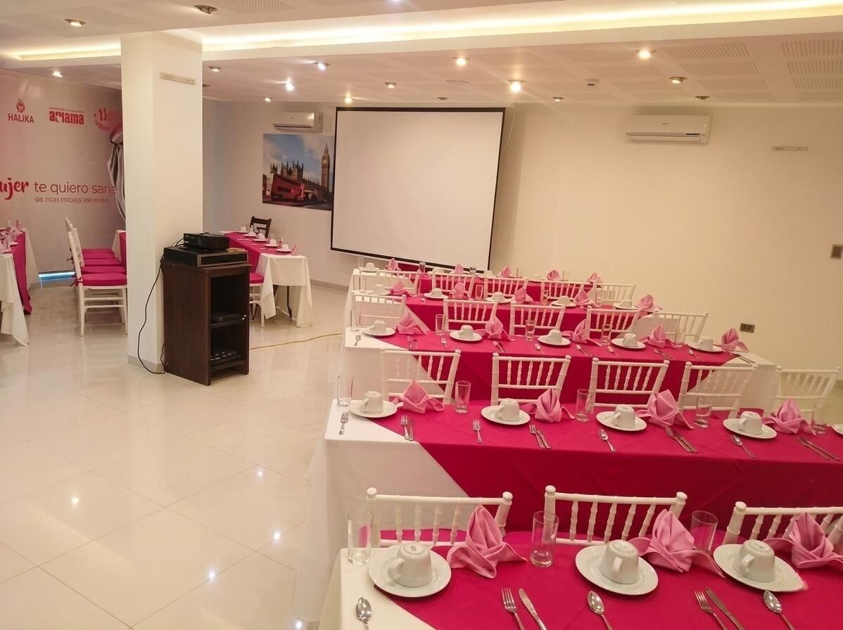 A conference room with tables set for a meeting, a podium, and a projection screen.