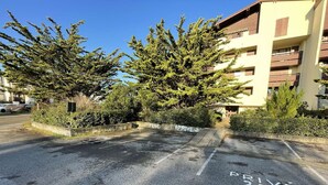 A parking area with 'PRIVE 2' marked on the ground, surrounded by trees and a building with balconies. - Seignosse Ocean,  with a parking space, near beach, 4 pers. ideal family (SEIGNOSSE)