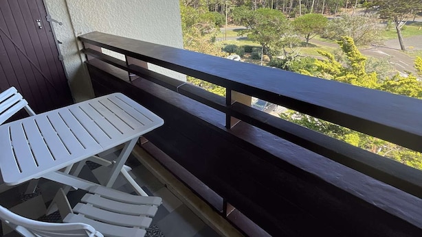 A balcony with a table and chairs, a view of trees and a golf course. - Seignosse Ocean,  with a parking space, near beach, 4 pers. ideal family (SEIGNOSSE)