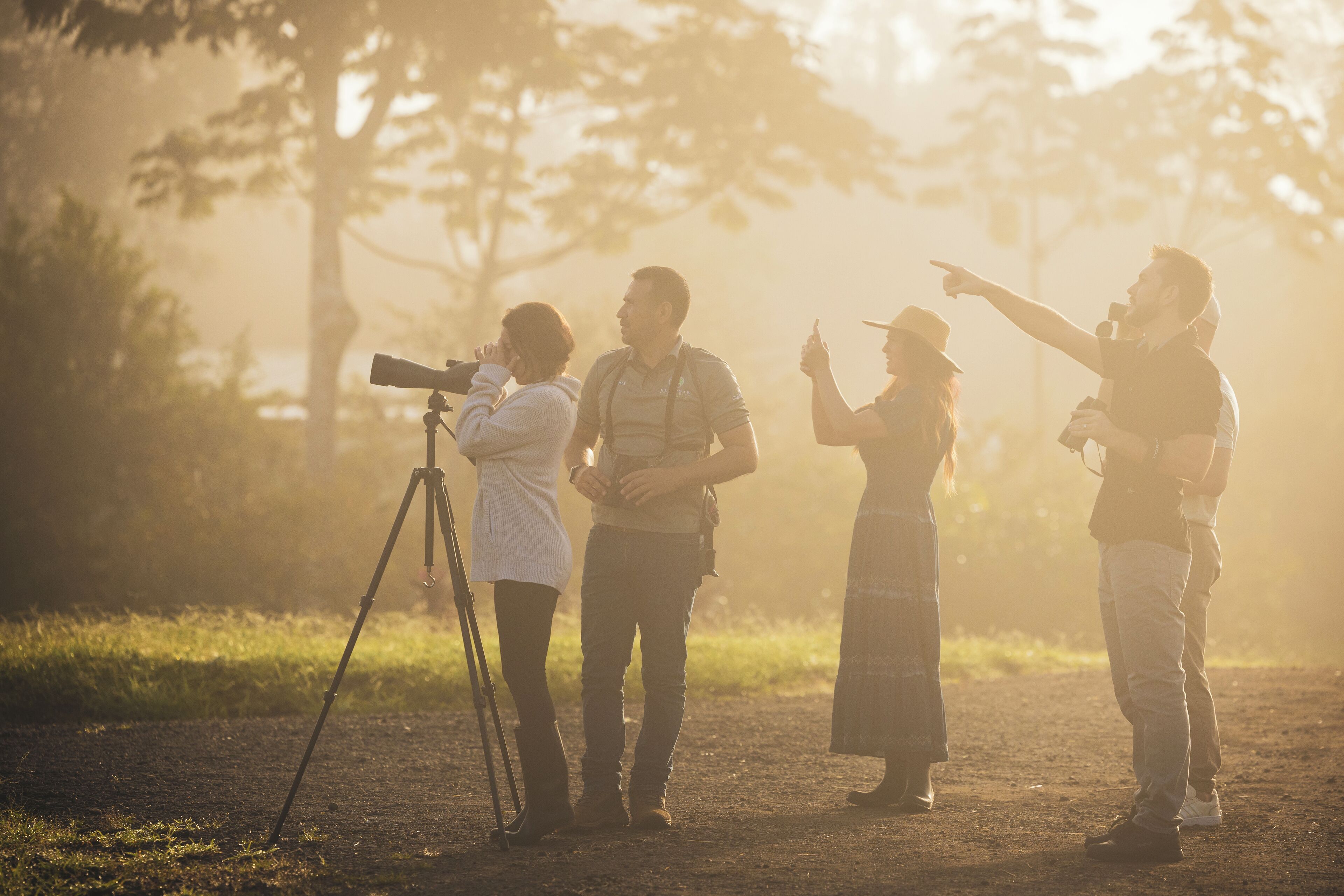 A group of people outdoors with a camera on a tripod.