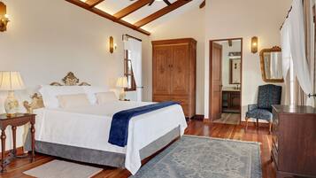 Un dormitorio con cama, armario de madera, silla y espejo.