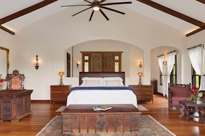 A spacious bedroom with a large bed, wooden headboard, and a ceiling fan. - El Lugar Hotel, Nature Reserve Costa Rica (Las Horquetas)