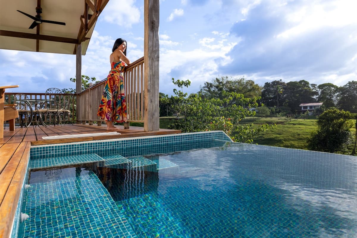 A pool with a wooden deck and a view of the surrounding landscape.