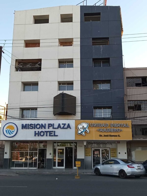 A building with a sign for 'Mission Plaza Hotel' and 'Unidad Dental Madero'.