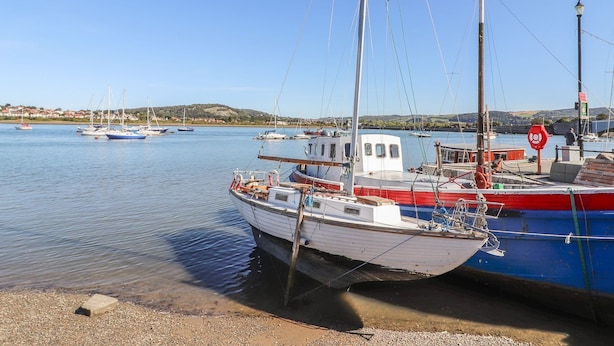Un porto con barche ormeggiate, acqua calma e cielo sereno.