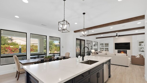 A modern kitchen with a large island, dark cabinetry, and pendant lighting. - Serenity Retreat at Montage, by GPM - Pool + Gameroom + More! Walk to Festivals (Indio)