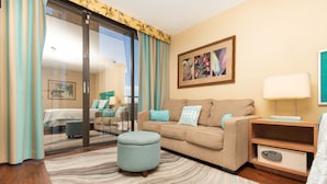 A modern hotel room with a sofa, ottoman, and a nightstand with a lamp. - *Free Parking*Beautiful Views*10 Min to Beach* (Honolulu)