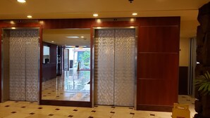 A hotel lobby with a check-in counter, a reception desk, and a glass elevator. - King Size Bed*Free Parking*Walk to the beach (Honolulu)