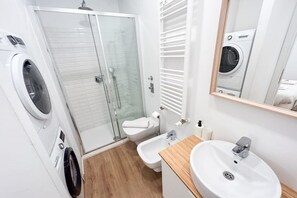 Enjoy a refreshing shower in the bathroom, featuring a glass-enclosed shower area, a toilet, bidet, and sink with a countertop.