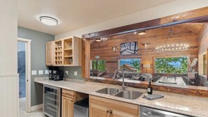 Une cuisine moderne avec des meubles en bois, des appareils en acier inoxydable et une grande fenêtre donnant sur un paysage magnifique.
