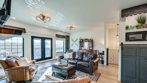 A spacious living room with leather sofas, a coffee table, and a fireplace. - Stellar Craig Apartment - Walk to Restaurants! (Craig)