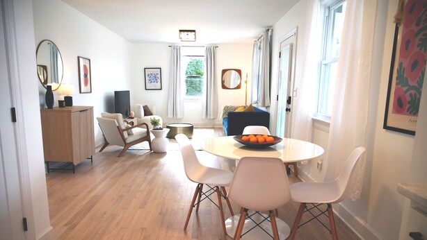 Ein modernes Wohnzimmer mit Essbereich, Holzboden und Blick ins Freie.
