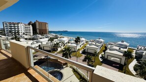 Un resort con varias edificaciones blancas, una piscina y vista al océano.