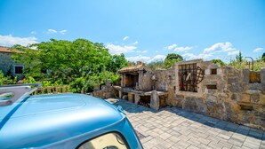 A stone building with a tiled roof, a paved driveway, and a parked car. - Villa Plovanija (Kvarner - Poljica) (Poljica)