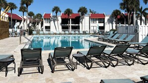 A pool area with lounge chairs and a clear blue sky. - Runaway Bay 247 - Beach, pool, bay and gym (Bradenton Beach)
