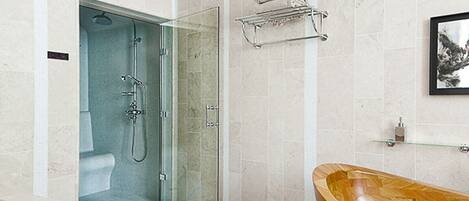 A modern bathroom with a glass-enclosed shower, a wooden bathtub, and a towel rack on the wall.