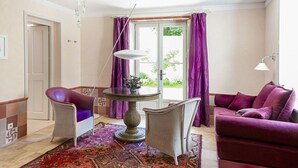 A living room with a round table, two armchairs, a sofa, and a chandelier. - Bed & Breakfast in the town center (La Rochelle)