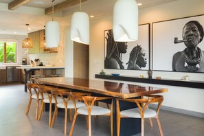 A modern kitchen with a large wooden island, pendant lights, and artwork on the walls. - Named the Top 5 Vacation Rentals in the World by CBS Destination Channel (Peninsula papagayo)
