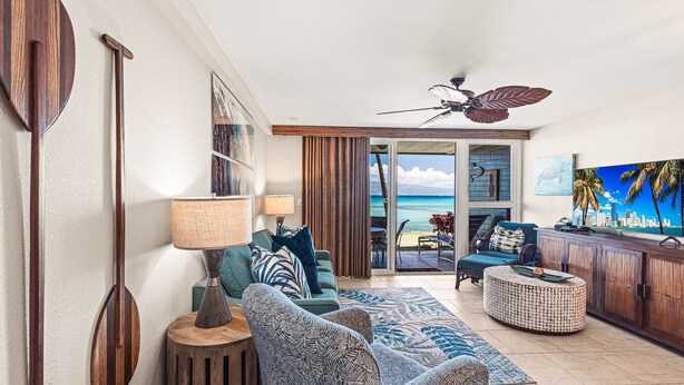 A living room with a view of the ocean, a ceiling fan, and a bar area. - Luxury meets space in this Premium 1bd Oceanfront (Lahaina)