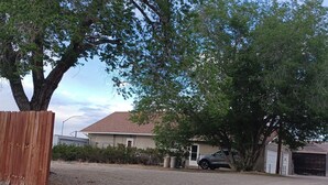 A residential area with a house, a parked car, and a gravel driveway. - The Shopkeeper's Inn. 
Unique property with history, In the heart of Ely, Nv. (Ely)