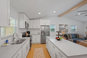 A modern kitchen with white cabinets, stainless steel appliances, and a central island. - 50 Shades of Slade | Private Hot Tub, Pet-Friendly + 5 Minutes to Natural Bridge (Stanton)