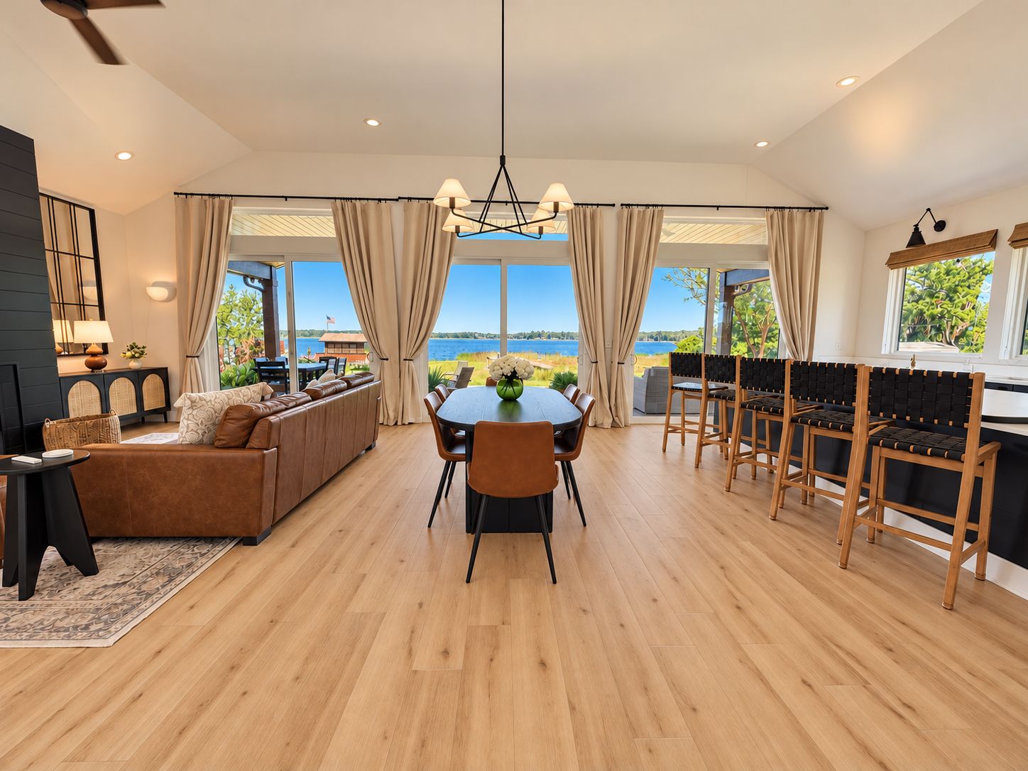 Un amplio salón con una mesa de comedor, sofás y vistas al exterior.