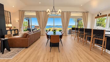 Un amplio salón con una mesa de comedor, sofás y vistas al exterior.