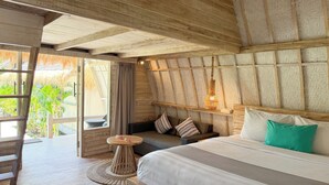 A room with a bed, a round wooden table, a woven floor mat, and a view of greenery outside. - Gili Air Escape - Adults Only (Gili Air)