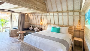 A room with a bed, bedside tables, a small round table, and a view of the outdoors. - Gili Air Escape - Adults Only (Gili Air)