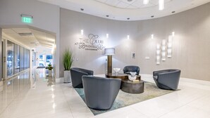 A modern lobby with a reception desk, seating area, and an exit sign. - Miami Brickell unit Balcony Pool 1 pkg (Miami)