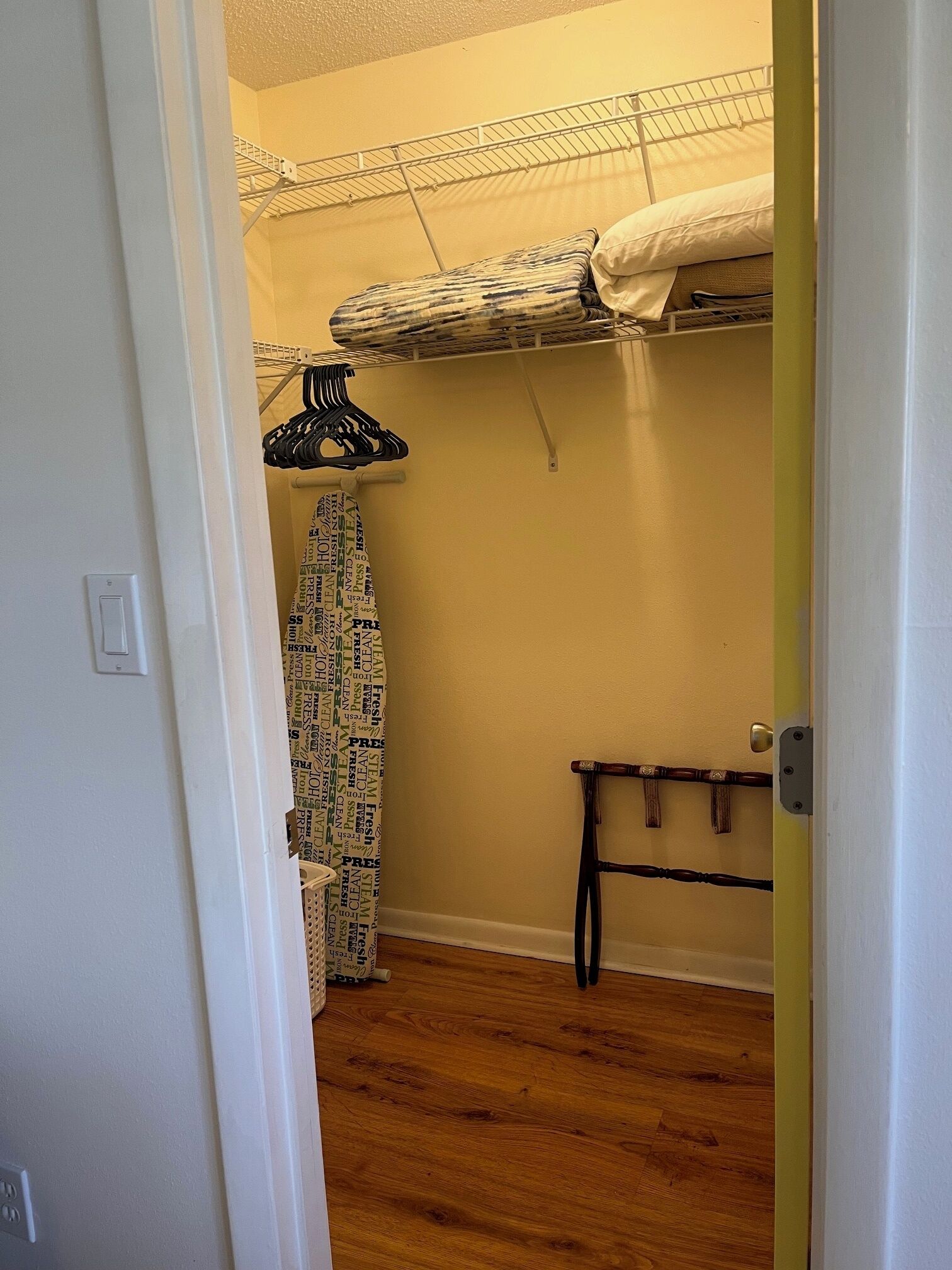 Un dormitorio con una cama litera, un tendedero y un banco de madera.
