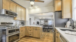 Une cuisine moderne avec des meubles en bois, des appareils électroménagers en acier inoxydable et un îlot central.