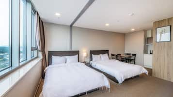 A hotel room with two beds, a desk, and a chair.