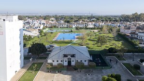 Un bâtiment portant une enseigne indiquant « LA SALINERA », entouré d’une cour bien entretenue avec une piscine, des arbres et un ciel dégagé.